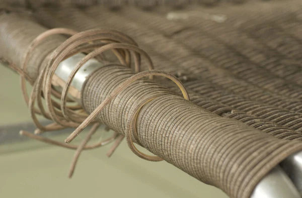 A close-up of a damaged wicker chair.