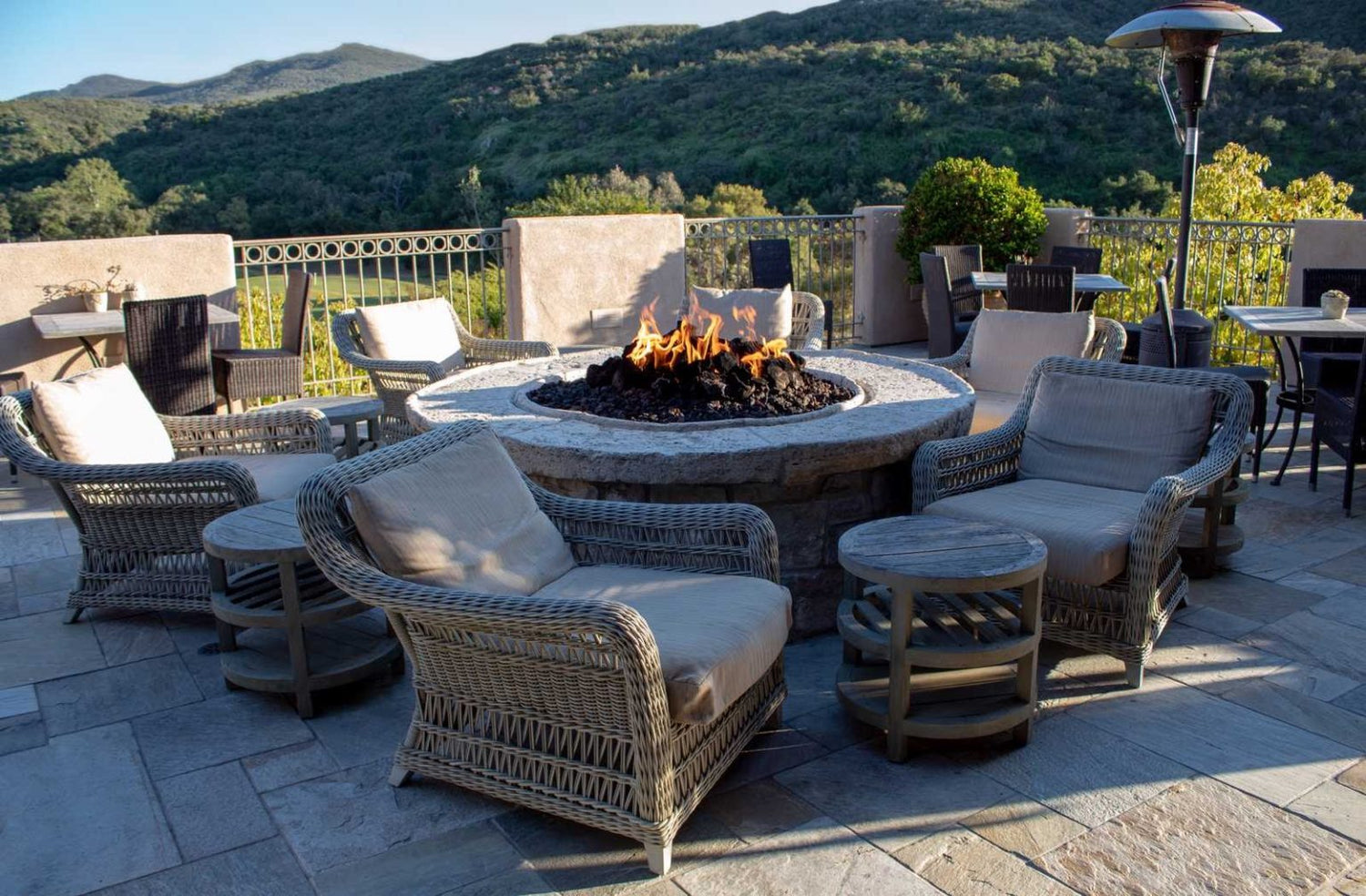 Fire table with multiple cushioned chairs surrounding it