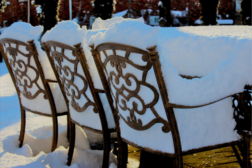 Patio Chairs in winter piled with snow