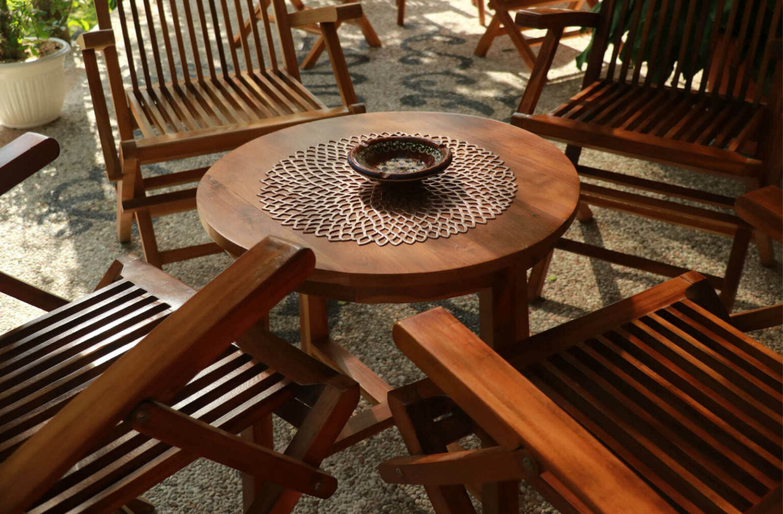 Four wood chairs around a wood table on a patio
